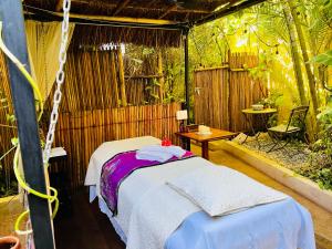 een slaapkamer met 2 bedden in een kamer met bomen bij Hacienda Boutique B&B and Spa Solo Adultos in Cozumel