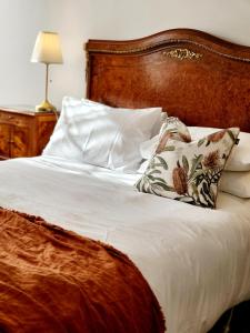 a bed with a wooden headboard and two pillows at Annesley House in Portland