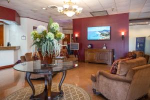 una sala de espera con una mesa con un jarrón de flores en GreenTree Hotel & Extended Stay I-10 FWY Houston, Channelview, Baytown, en Channelview
