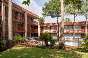 an apartment building with a pool and trees at GreenTree Hotel & Extended Stay I-10 FWY Houston, Channelview, Baytown in Channelview
