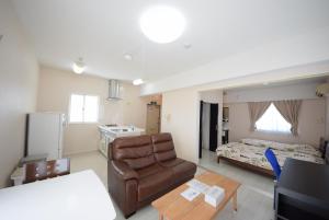 a living room with a couch and a bed at Sumuka shintoshin2 901 1LDK in Naha
