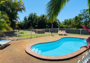 a small swimming pool with a table and two chairs at Costa Rica Motel in South West Rocks
