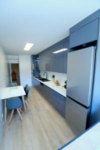 a kitchen with a white table and a refrigerator at Diamante house com garagem privada in Braga