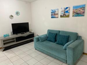 un salon avec un canapé bleu et une télévision dans l'établissement Alto Belgrano II, à Mendoza