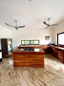 a large room with a kitchen with two ceiling fans at VILLA LA MARQUESA in Puerto Escondido