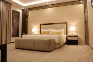 فندق وايت مون للأجنحة الفندقية في خميس مشيط: غرفة نوم كبيرة بها سرير كبير ومصباحين