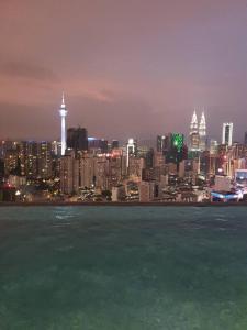 a view of a city at night with the water at Infinity pool/ Lucentia BBCC, near LALAPORT, PNB118, KLCC in Kuala Lumpur