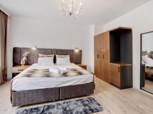 a bedroom with a large bed and a chandelier at Deluxe Apartment in Oberhausen with Breakfast in Oberhausen
