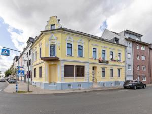 ein gelbes Gebäude an der Ecke einer Straße in der Unterkunft Deluxe Apartment in Oberhausen with Breakfast in Oberhausen
