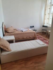 a bedroom with two beds and a table at Cazare - Accommodation in Bucharest