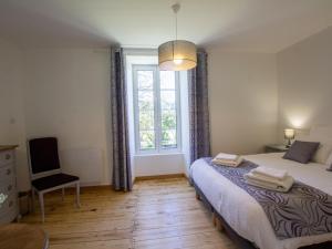 a bedroom with a bed and a window and a chair at Grande maison rénovée avec piscine privée et parc, idéale pour vacances en famille en Dordogne - FR-1-616-216 in Savignac-les-Églises +23 photos