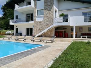 a house with a swimming pool next to a building at Appartement Urt, 3 pièces, 8 personnes - FR-1-239-795 in Urt