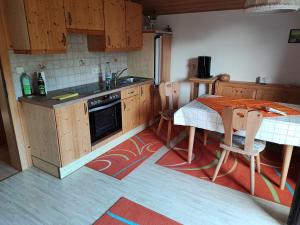 a kitchen with wooden cabinets and a table and a table and chairs at Hochbergerhof in Rottenmann