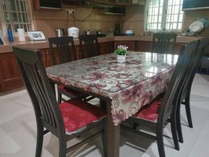 a dining room table with chairs and a table cloth at 3R3B in Kota Bharu near Datu River in Kota Bharu