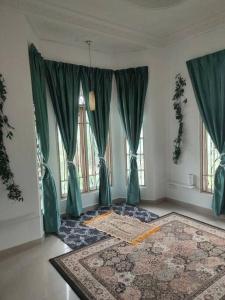 sala de estar con cortinas verdes y alfombra en 3R3B in Kota Bharu near Datu River en Kota Bharu
