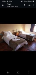 two beds in a hotel room with at Pousada Casarão da Pedra in Congonhas