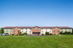 a row of brick apartment buildings with a green lawn at Super 8 by Wyndham Lenexa Overland Park Area/Mall Area in Lenexa