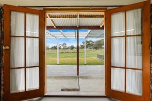 uma porta aberta com vista para um campo em Summerfield Winery and Accommodation em Moonambel