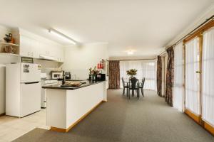 a kitchen with white appliances and a table and chairs at Summerfield Winery and Accommodation in Moonambel