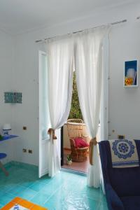 una puerta abierta con cortinas blancas en una habitación en B&B Sognava, en Salerno