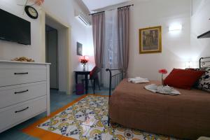 1 dormitorio con 1 cama con cómoda y TV en B&B Sognava, en Salerno