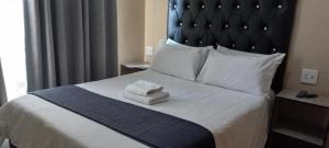 1 dormitorio con 1 cama con 2 toallas en M n M Guesthouse In Turfloop Mankweng en Polokwane
