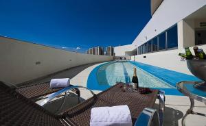 a swimming pool with a table and a bottle of wine at PROMOÇÃO EXECUTIVA COM BANHEIRA E FLATS SEM BANHEIRA- Melhor Hotel De Taguatinga in Taguatinga