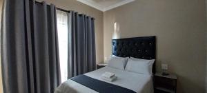 a bedroom with a bed with a large window at M n M Guesthouse In Turfloop Mankweng in Polokwane