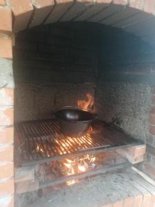 una olla en un horno de ladrillo con una sartén en Conacul Elenei en Poiana Mărului