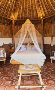 a bedroom with a bed in a straw hut at ECOZY by Biji Valley in Selat