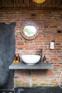 a bathroom with a sink on a brick wall at ECOZY by Biji Valley in Selat
