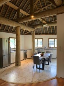 a kitchen and dining room with a table and chairs at Fale Tonga Guesthouse in Puke