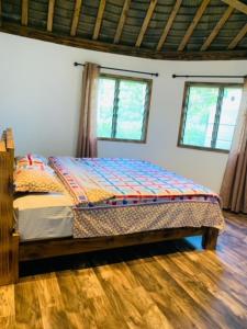 a bedroom with a bed in a room with two windows at Fale Tonga Guesthouse 