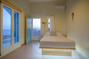 1 dormitorio con 1 cama y vistas al océano en Ios stylish house Panoramic Sea and Sunset view, en Ios Chora