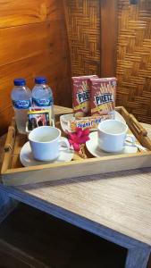 uma bandeja com duas chávenas e batatas fritas e bebidas numa mesa em Light Blue Villa em Tepus