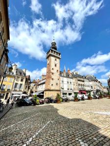 une tour d'horloge au milieu d'une rue urbaine dans l'établissement Appartement cosy Centre ville, à Moulins