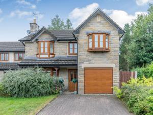 a brick house with a garage in front of it at 2 Carr Farm Close in Glossop
