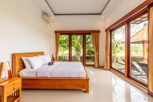 a bedroom with a bed and a large window at Private Pool Villa - Villa Saia Ubud in Ubud