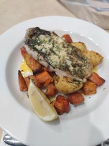 um prato de comida com peixe e batatas e um limão em Sir Francis Drake em Heatherbrae