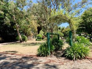 a garden with an arch in a park with plants at Fernleigh Accommodation in Goughs Bay