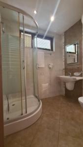 La salle de bains est pourvue d'une douche et d'un lavabo. dans l'établissement Апартамент Лагуна Aйланд, à Sozopol