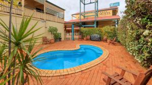 a swimming pool in the middle of a brick patio at Dalby Homestead Motel in Dalby