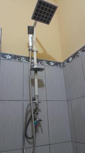 a shower head in a bathroom with a light on the ceiling at Suta Lovina House in Lovina