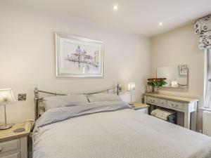 a bedroom with a bed and a desk with two lamps at Silvadale Cottage in Louth