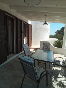 a glass table and chairs on a patio at Villa Anna Maria in Polignano a Mare