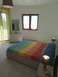 a bedroom with a large bed with a colorful blanket at Villa Anna Maria in Polignano a Mare