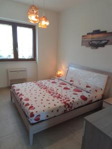 a bedroom with a bed with red flowers on it at Villa Anna Maria in Polignano a Mare