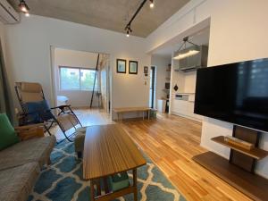 a living room with a large flat screen tv at FUSHIME in Motobu