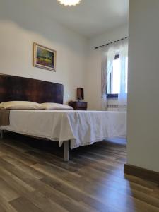 a bedroom with a large bed with a wooden headboard at Foresteria del Re in Montelupone +8 photos