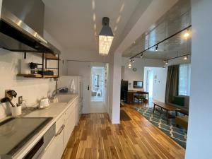 a kitchen with white cabinets and a wooden floor at FUSHIME in Motobu
